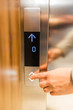Close up of businessman hand pressing modern elevator button. Space for copy.
