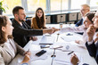 © F8  \ Suport Ukraine - Mature businessman shaking hands to seal a deal with his partner and colleagues in modern office