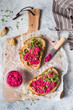 © nata_zhekova - Bruschetta with Beetroot hummus decorated with chopped nuts and microgreen. Vegan recipes, plant-based dishes. Green living concept. Organic food. Vegetarian cuisine. Bread with pink dip