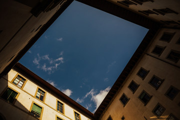 Classic architecture with sash windows and red roofs in Florence, Italy. Rooftop of the old building under blue sky. Roofing tiles. Place for text.  