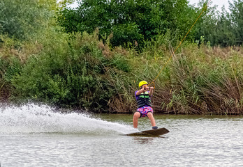 Teenager wakeboarding on a lake - Brwinow, Masovia, Poland