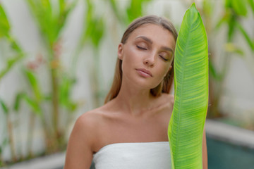 Sticker - Portrait of a beautiful young girl with a green leaf. Spa treatments.