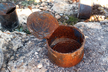 Open Old Rusty Tin Cans Covered With Ash On Rock