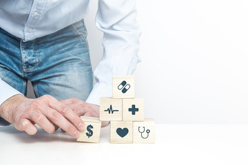  Medical symbols on wooden blocks. Medical and pharmaceutical concept. Health insurance, validity of money during treatment, financial and health problems.