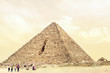 Tourists and Bedouins stand by Pyramid of Menkaure on the Giza Plateau