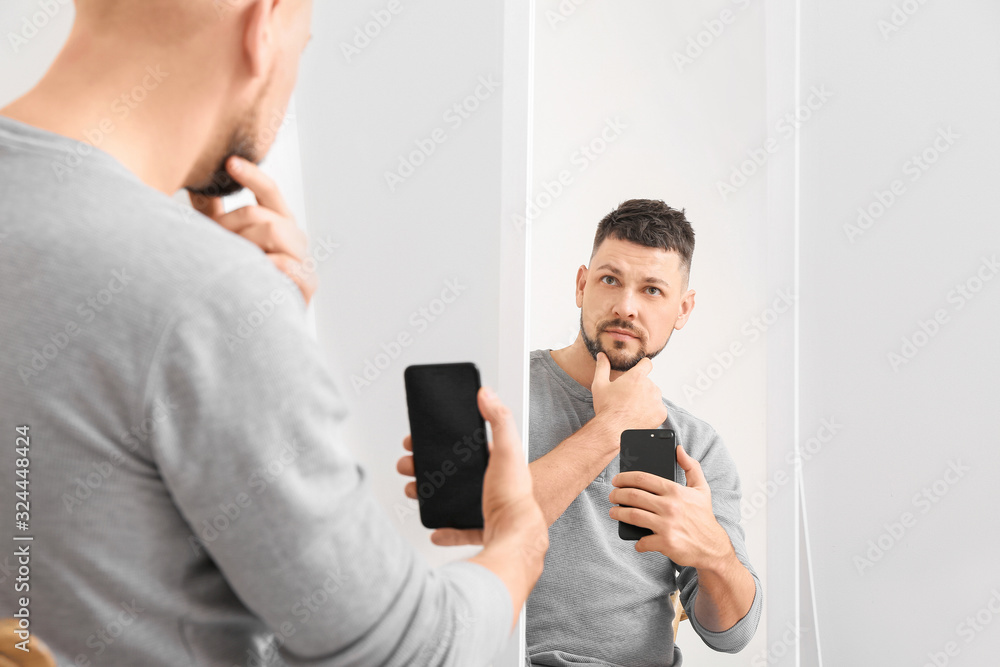 Man taking selfie in front of mirror at home