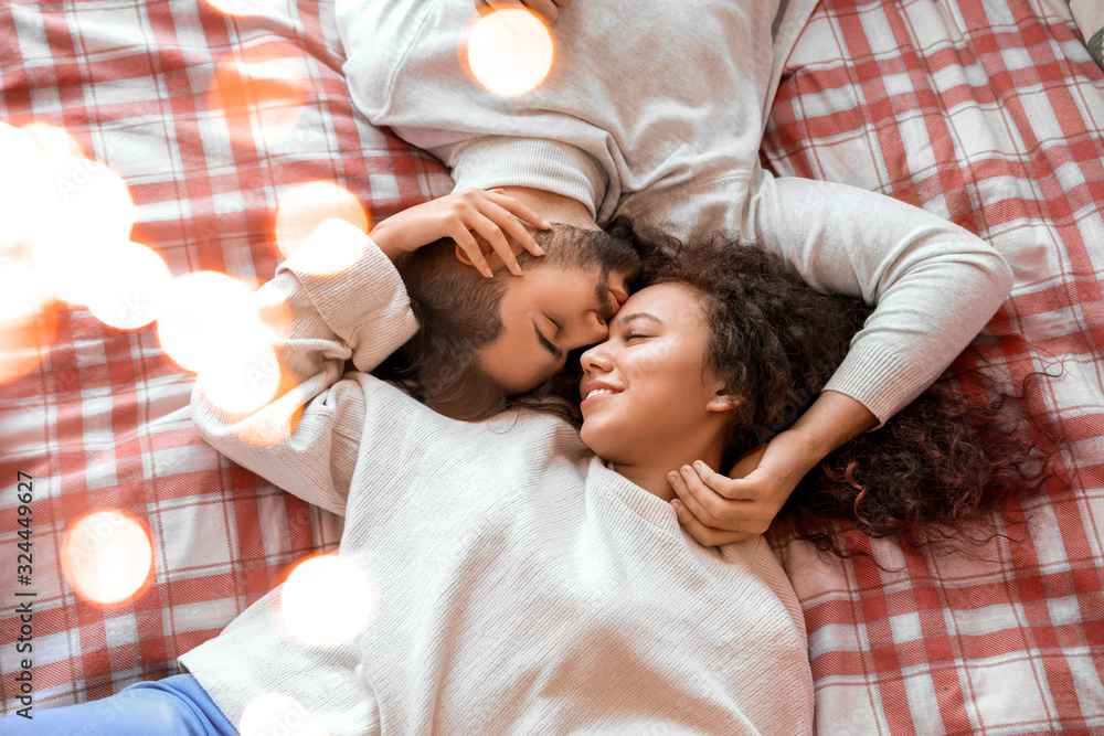 Happy young couple lying on bed at home