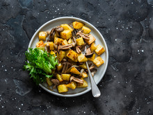 Fried Potatoes With Mushrooms And Green Salad - Delicious Simple Vegetarian Lunch On A Dark Background, Top View