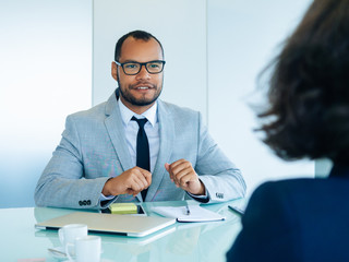 Wall Mural - Business partners meeting in boardroom for negotiation. Business man and woman sitting at conference table opposite of each other. Business meeting concept