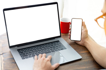 mockup image blank screen computer,cell phone with white background for advertising text,hand man using laptop texting mobile contact business search information on desk in office.marketing,design