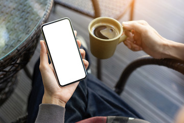 Mockup image blank white screen cell phone.man hand holding texting using mobile on desk at coffee shop.background empty space for advertise text.people contact marketing business,technology