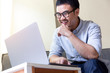 © panitan - using computer.asian man hand typing message keyboard laptop chatting friend.search information form internet while sitting on sofa.concept for use technology device contact communication business
