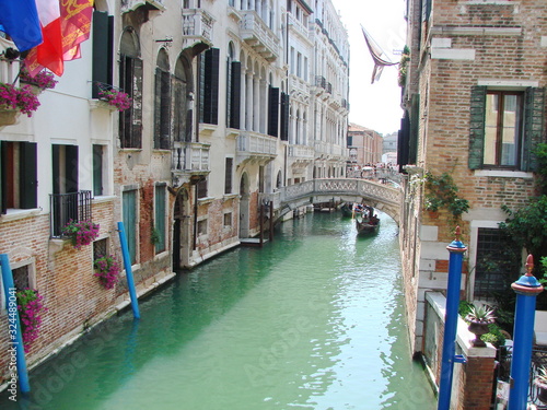 The unique landscape of the narrow waterways of sunny Venice, connected by small numerous bridges. © Hennadii