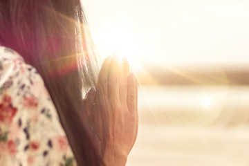 A woman praying hand for blessings When the sun goes down Hope for a happy life