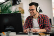 © JustLife - Businessman on video call. Handsome man in office with headphones.
