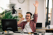 © JustLife - Attractive businessman in office. Young programmer with headphones singing at work.