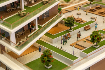 Miniature people in modern residential complex.