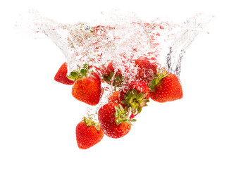 Wall Mural - Strawberries falling into water causing bubbles all around it. Healthy food concept