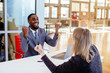 © Carlos David - Portrait of a happy smiling young man in business suit celebrating with fists up with woman coworker or client in office meeting