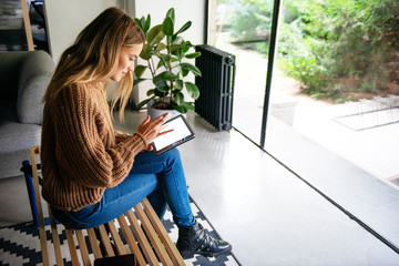 Young women typing on digital tablet, holding credt card