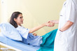 © eakgrungenerd - Doctor and patient holding hand together, medical professionals, health care in room of hospital.
