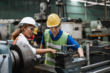 Wall Mural - Man and woman engineer industry worker wearing hard hat in factory,