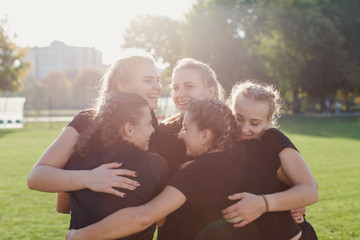 Sportive women embracing on a football pitch