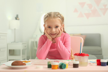 Sticker - Cute little child painting at table in room