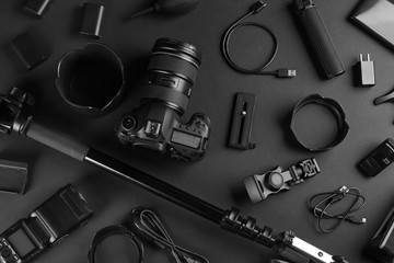 Wall Mural - flat lay composition with camera and video production equipment on black background