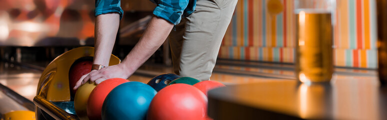  cropped view of man taking bowling ball, panoramic shot