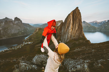 Family vacations mother holding up baby traveling in Norway hiking together active healthy lifestyle mom and kid outdoor happy emotions Segla mountain view