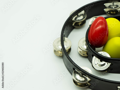 Fotografía Top view of black tambourine with egg shakers on a white background
