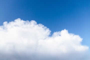 Wall Mural - Beautiful white big soft fluffy cloud on a clear blue sky background