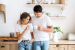 © Kateryna - Morning at home with coffee. Happy married couple in white t-shirts drinks together morning coffee at home in their cozy kitchen