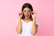© luismolinero - Young woman over isolated pink background with glasses and surprised