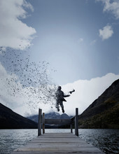 Man Floats Into Air Over Dock And Lake, Disintegrating And Dropping Camera 
