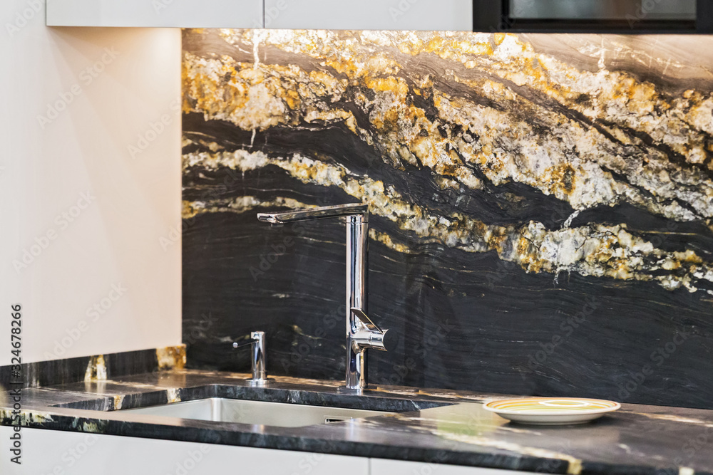 Beautiful modern kitchen design, kitchen faucet, black and gold stone marble countertop kitchen - obrazy, fototapety, plakaty 