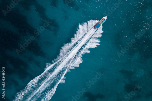 Bird eye view of motor boat with wake at sea
