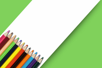  A row of color pencils on green background