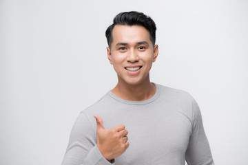 Poster - Young handsome man doing happy thumbs up gesture with hand. Approving expression looking at the camera showing success.