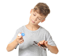 Wall Mural - Little boy with contact lens case and eyeglasses on white background