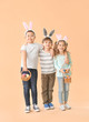 © Pixel-Shot - Little children with Easter eggs and bunny ears on color background