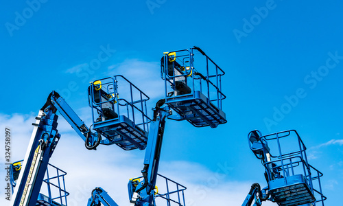 Articulated boom lift. Aerial platform lift. Telescopic boom lift against blue sky. Mobile construction crane for rent and sale. Maintenance and repair hydraulic boom lift service. Crane dealership.
