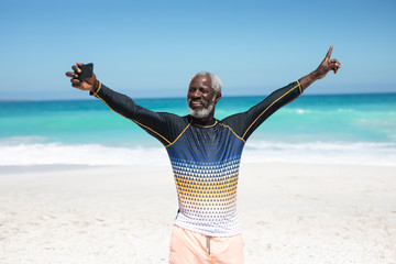 Wall Mural - Old man taking selfies at the beach