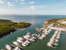 Marina Town With Waterfront River View Of Yachts And Boats In Sea Water. Carins Port Douglas Aerial View. Dramatic DRONE View From Above. Mountain Landscape In Background. Queenstown, Australia.