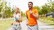 © Syda Productions - sport, healthy lifestyle and people concept - smiling couple with fitness trackers running along road on city street background