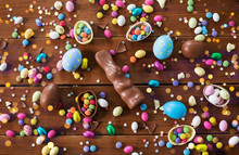 Easter, Sweets And Confectionery Concept - Chocolate Eggs, Bunny And Candy Drops On Wooden Background