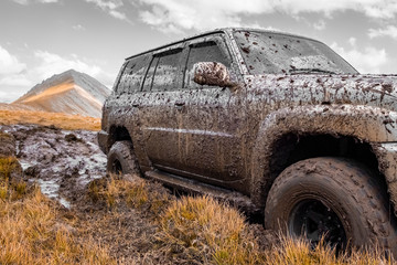 Adventure travel concept background. 4x4 off-road suv car stuck in mud. Adventure travel concept background. Offroad car.