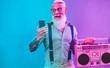 © DisobeyArt - Senior hipster man using smartphone app for creating playlist - Trendy tattoo guy having fun with mobile phone technology - Tech and joyful elderly lifestyle concept - Radial purple and blue filter