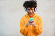 © DisobeyArt - Happy african millennial guy listening music playlist with smartphone app outdoor - Young man having fun with technology trends - Tech, generation z and stylish concept - Focus on face